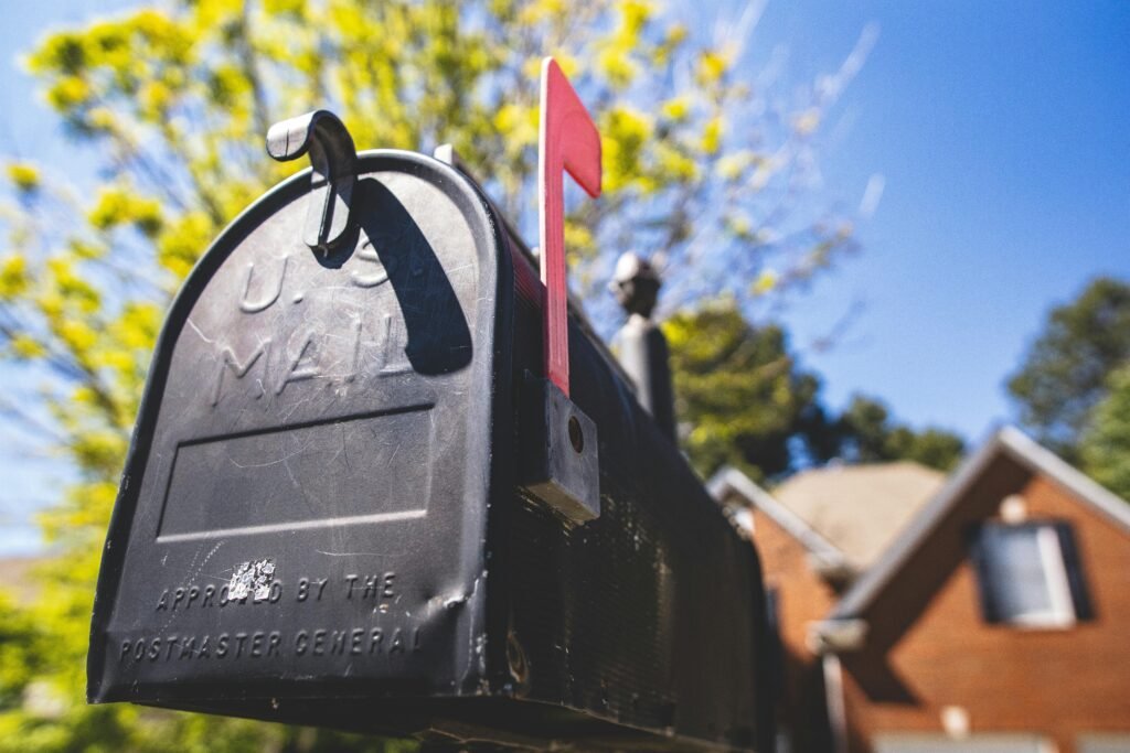 pexels-photo-2217613-2217613 Close-up of a traditional US mailbox with a red flag in a sunny neighborhood.